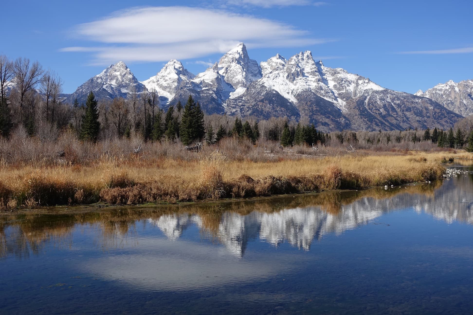 A river and mountains with snow topped peaks in the spring in Jackson Hole, Wyoming