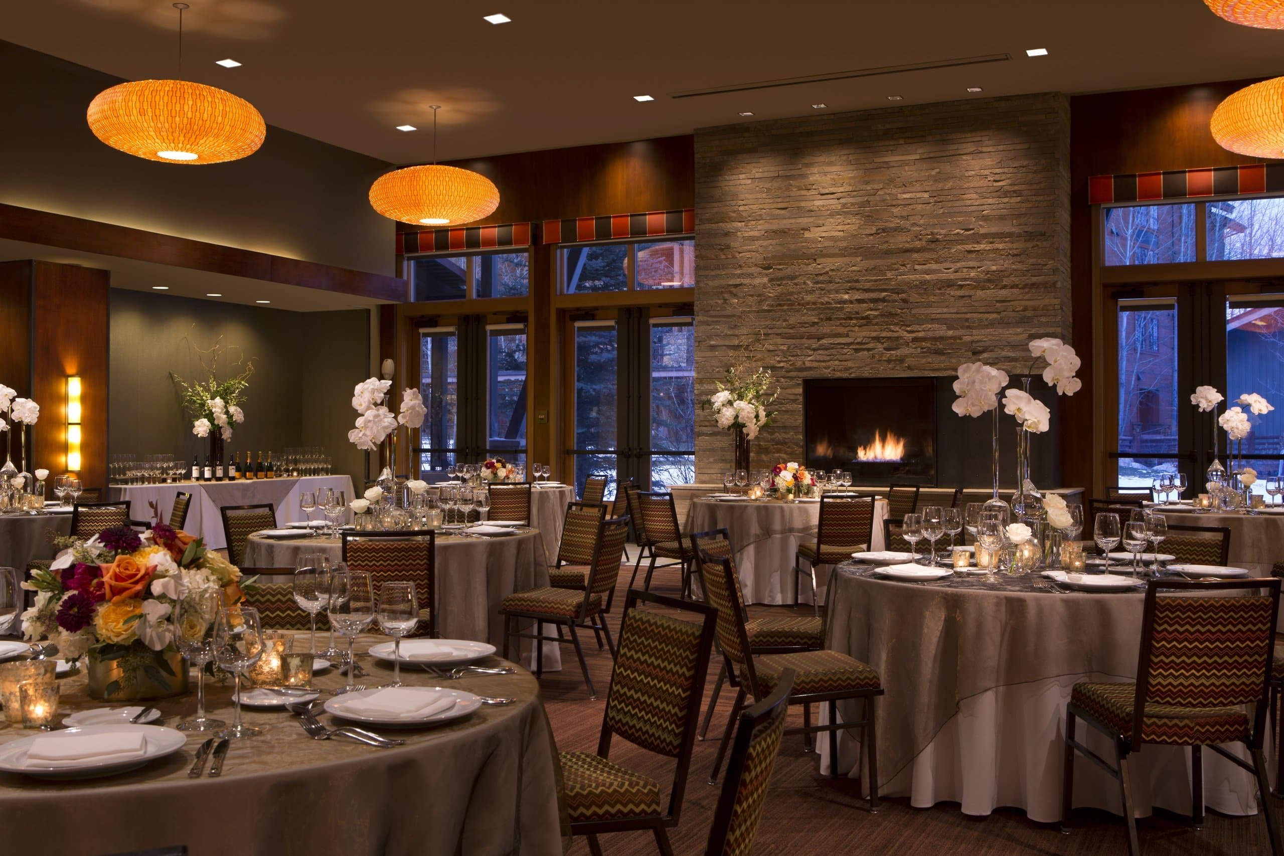 The Murie Ballroom set up for an evening wedding reception with formal arrangements at Hotel Terra Jackson Hole