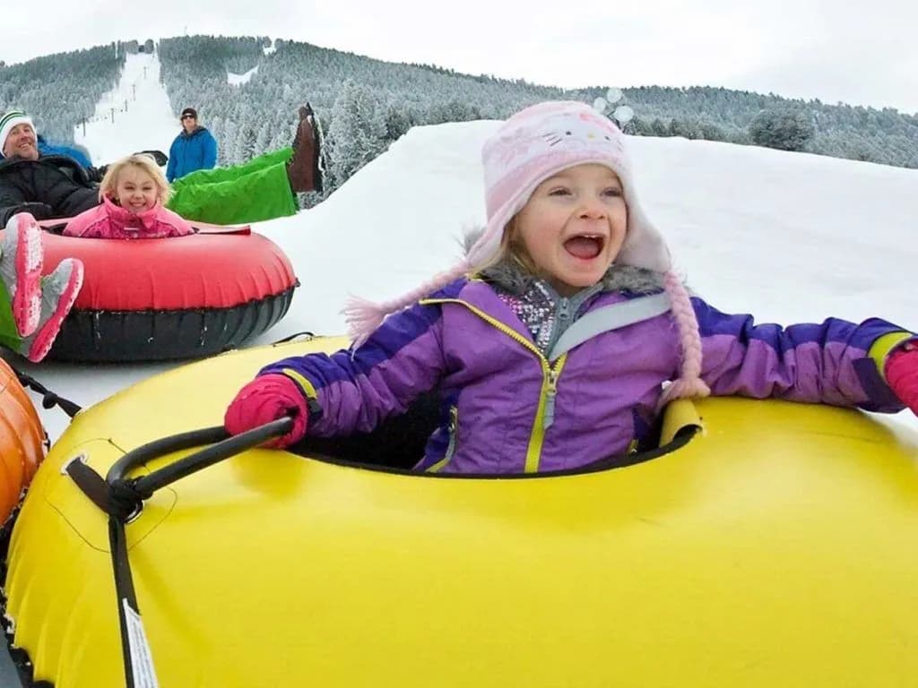 A family snowtubing at Snow King Mountain Resort, nearby to Jackson Hole in Wyoming