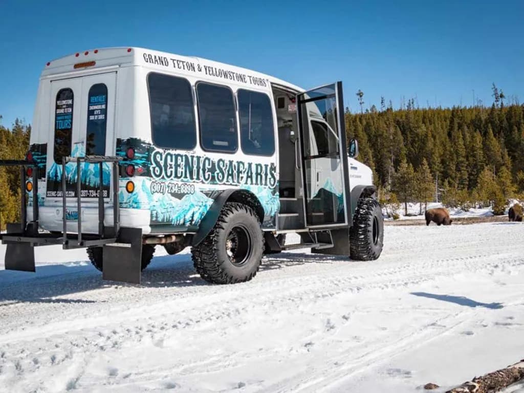 A Wildlife Safari bus stopped in the snow ahead of touring Grand Teton, Wyoming