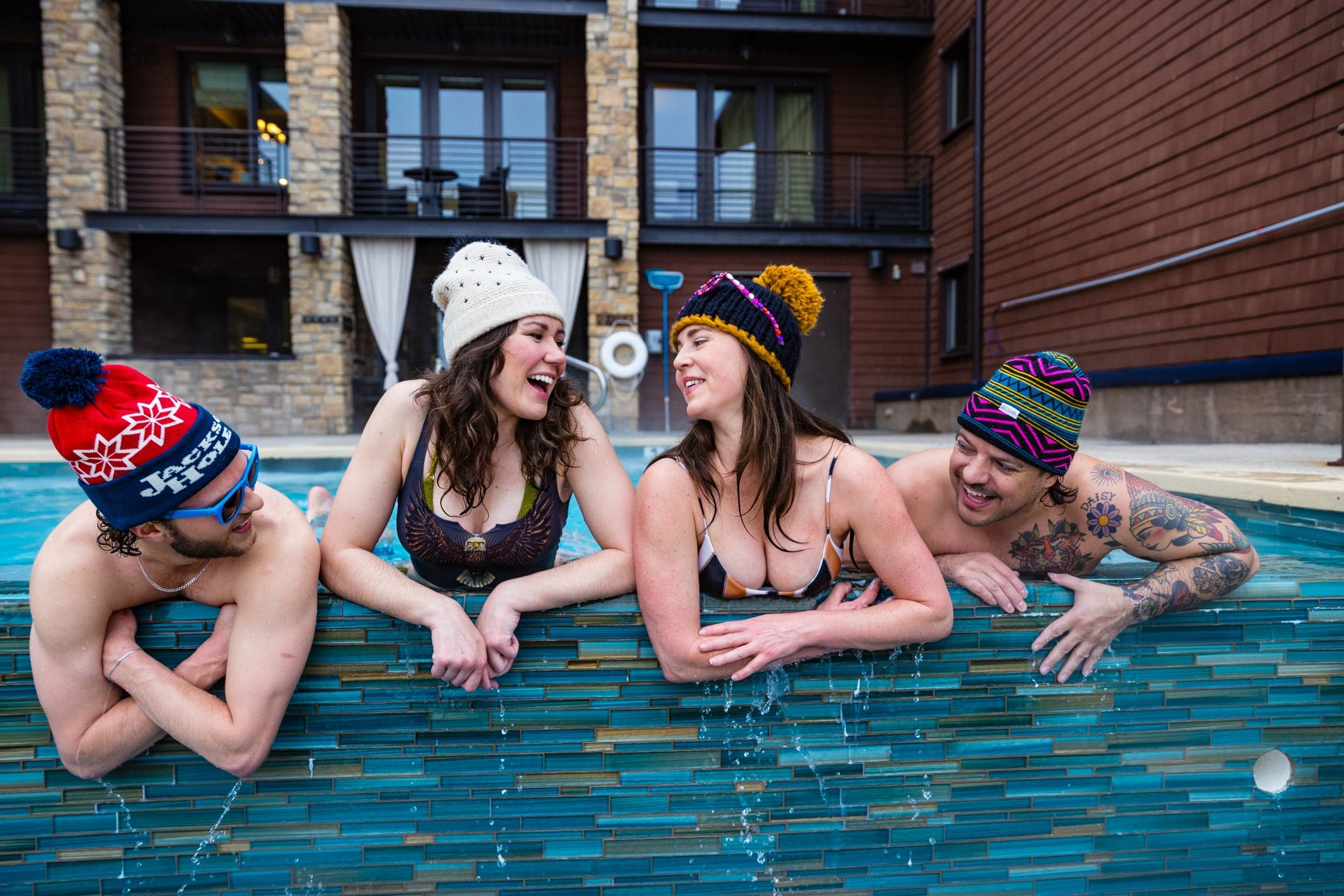 A group of friends socializing in the rooftop infinity pool at Hotel Terra in Jackson Hole, Wyoming