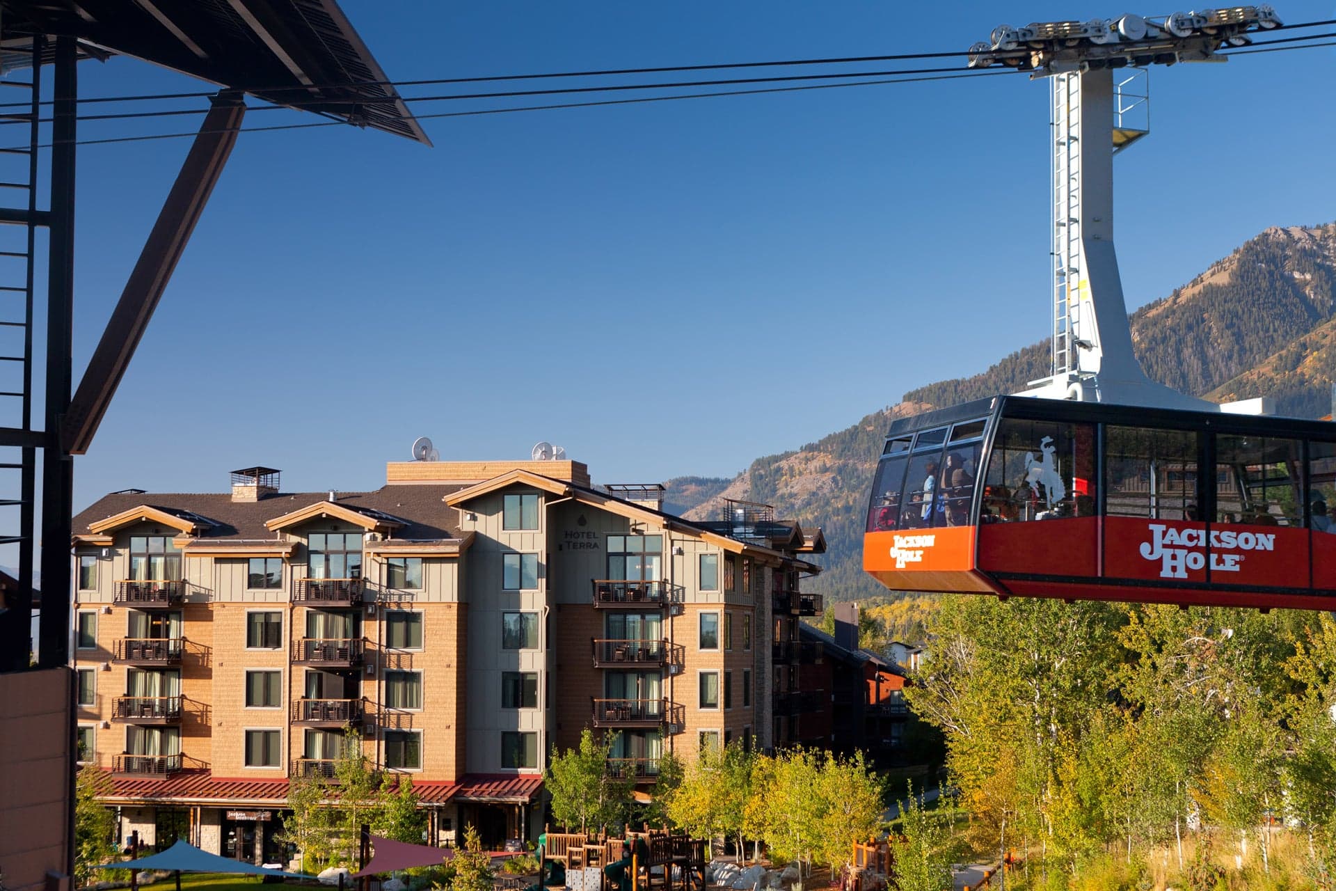 Aerial Tram going up the mountain with a view of Hotel Terra Jackson Hole in the background in Wyoming.