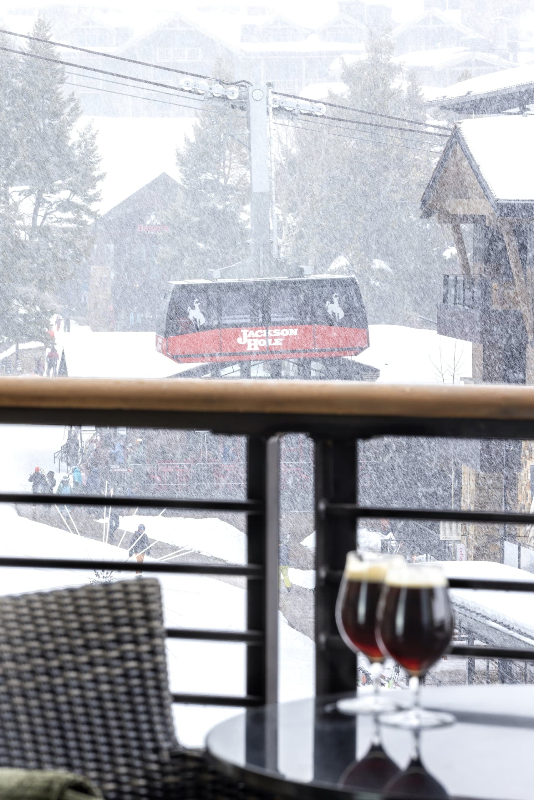 A balcony with 2 glasses of red wine on a table and a tram view at Hotel Terra