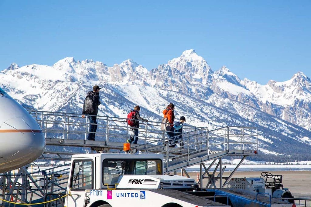 A group deplaning at Jackson Hole Airport (JAC) with snowy mountains of in the distance.