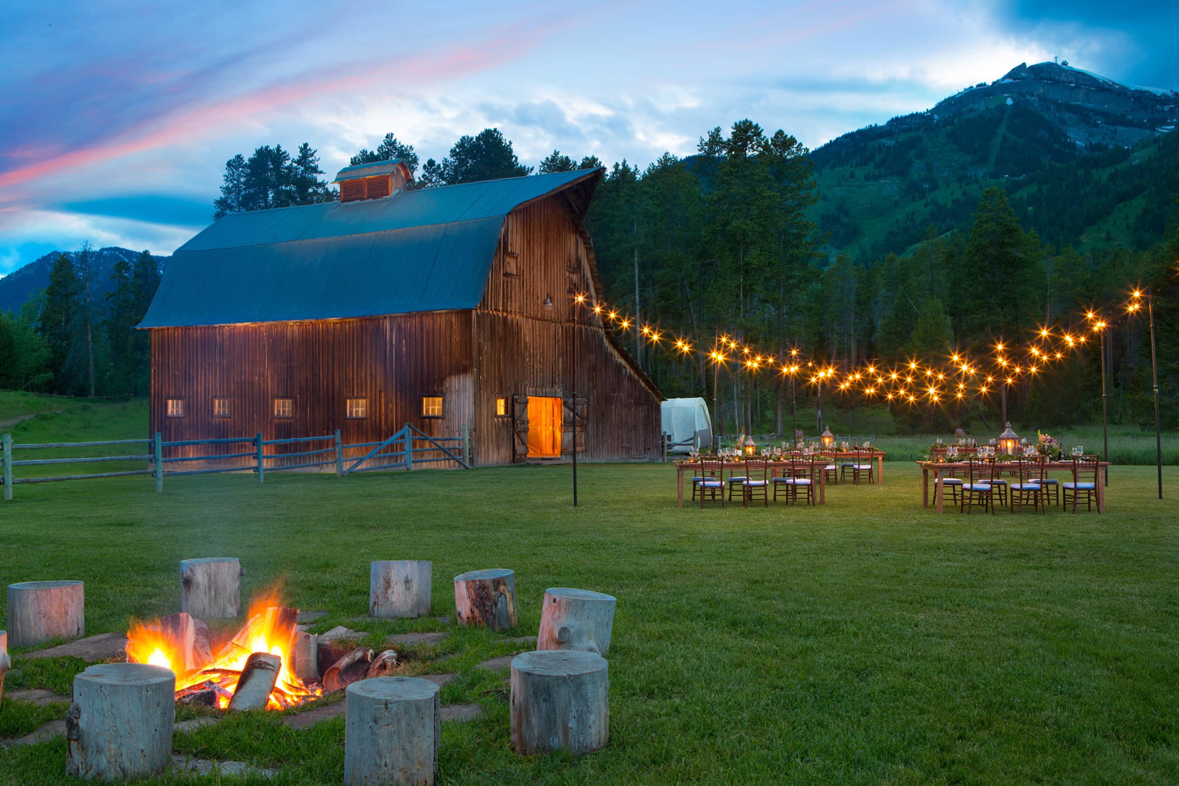 Rustic wedding venue at the Gray Barn in Jackson Hole Wyoming with menu by Spur Catering at dusk