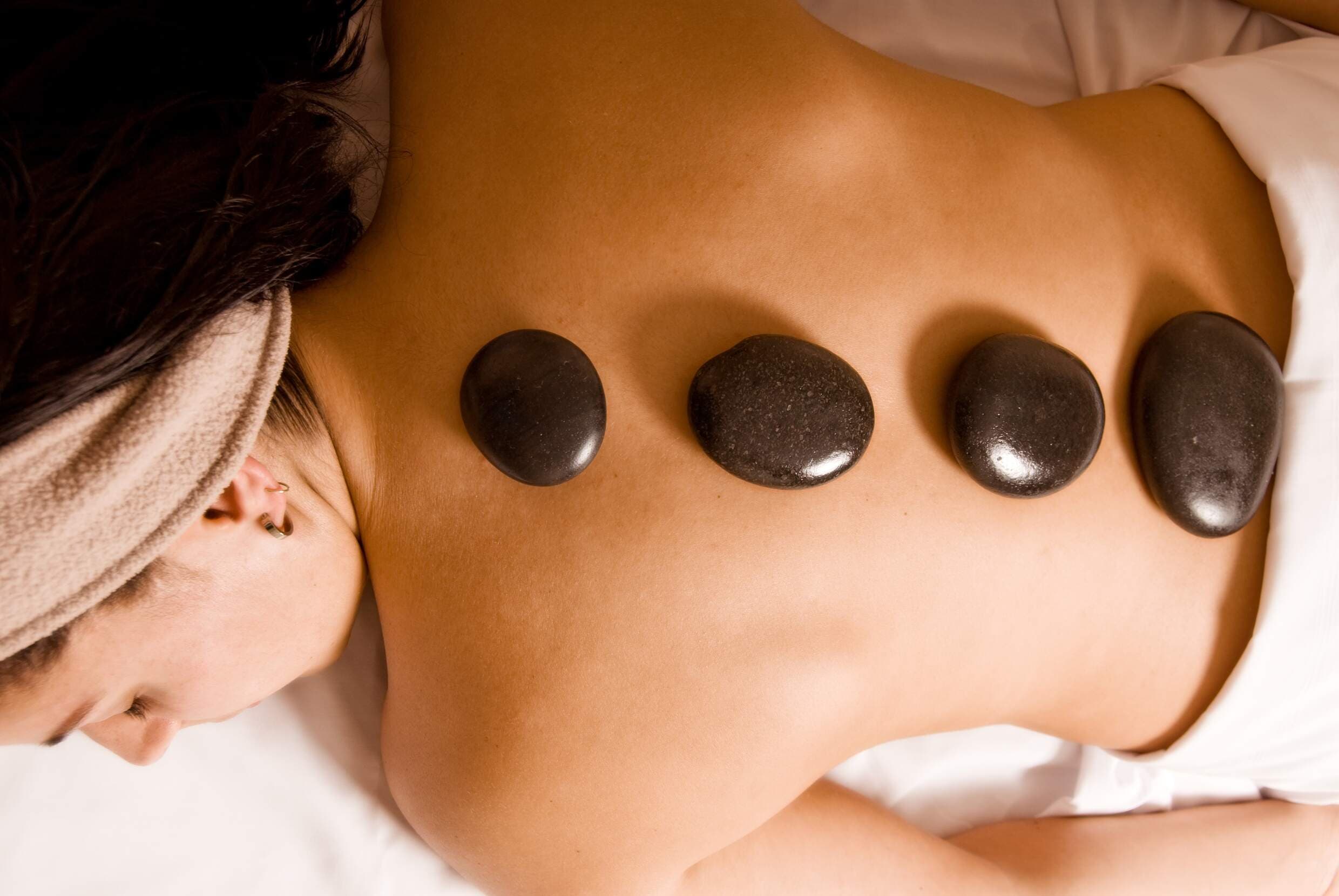 A woman getting a hot stone massage at Chlll Spa in Hotel Terra, Jackson Hone Wyoming.